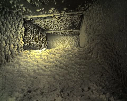 Inside view of a dirty air duct with dust surrounding the outside.