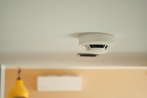 White carbon monoxide detector on ceiling at home